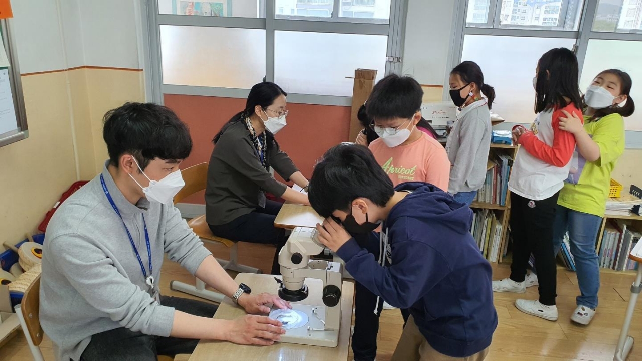 해부현미경을 통해 곤충의 마이크로 세계를 관찰하고 있는 학생들